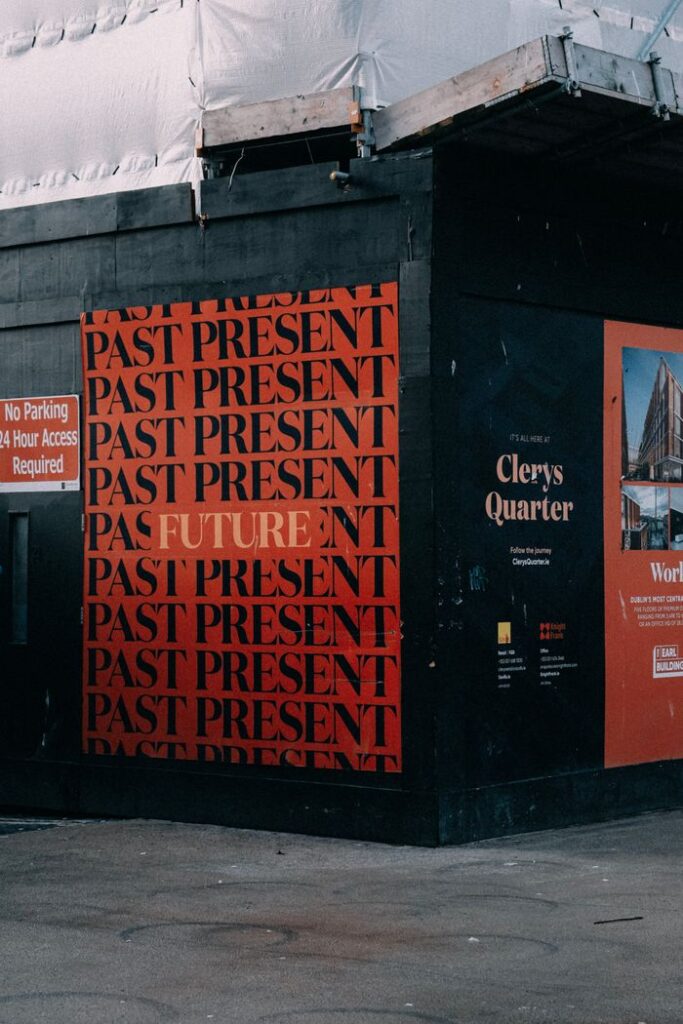 Vibrant city corner with striking 'Past, Present, Future' mural and urban signage.